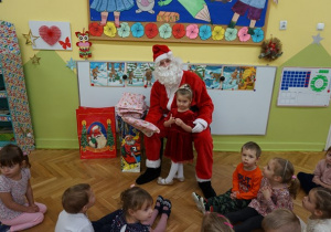 Mikołaj wręcza prezent Oliwii.